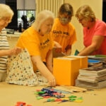 group of women assembling school supply kits