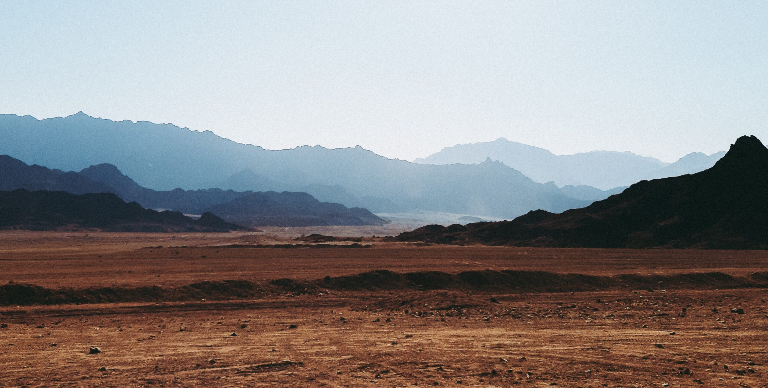 desolate landscape with mountains in the background